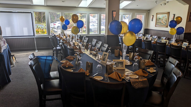 Long banquet table with blue and yellow balloons